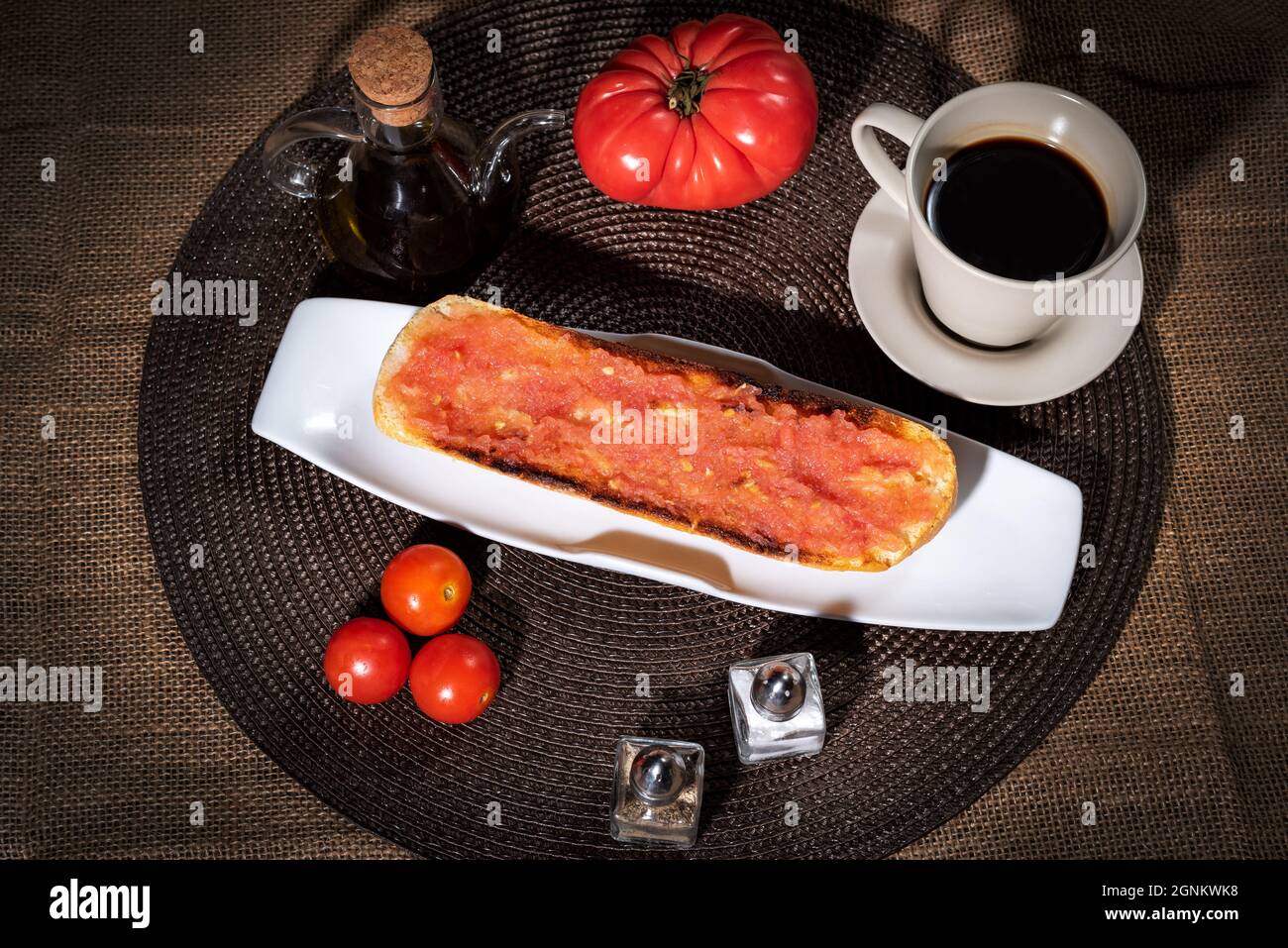 La prima colazione comprende un caffè e un toast con olio d'oliva e pomodoro. Foto Stock