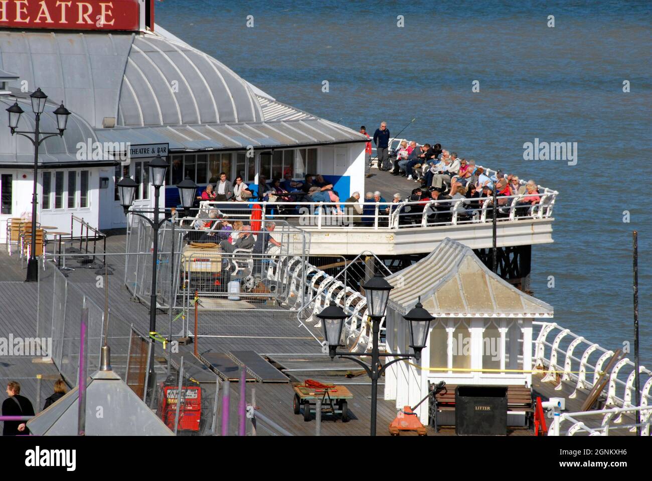 La folla di persone anziane che si godono il sole alla fine del molo Cromer, Norfolk, Inghilterra Foto Stock