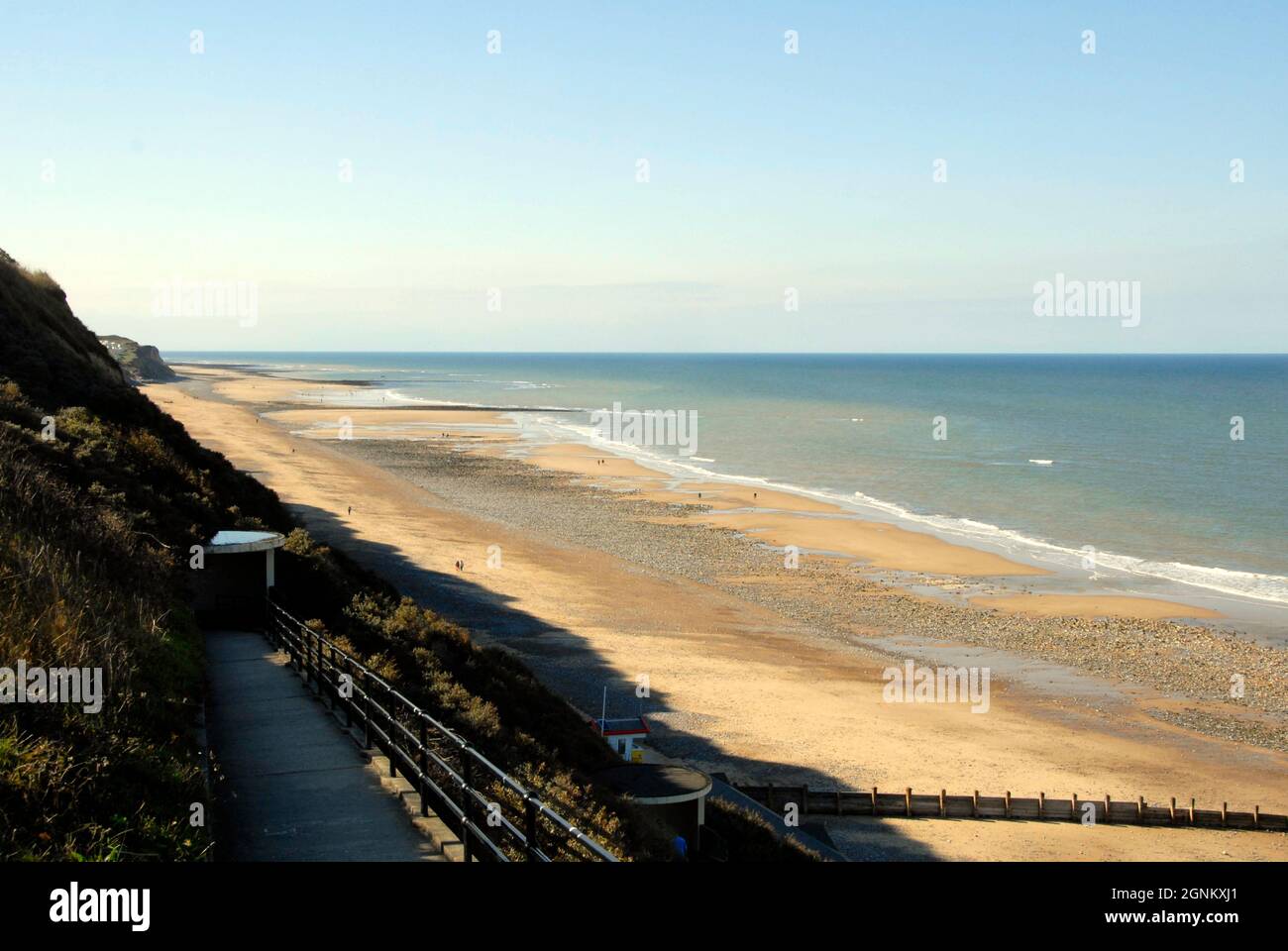 Percorso a zigzag che conduce dalla cima della scogliera fino ad una spiaggia vasta ma quasi vuota, Cromer, Norfolk, Inghilterra Foto Stock