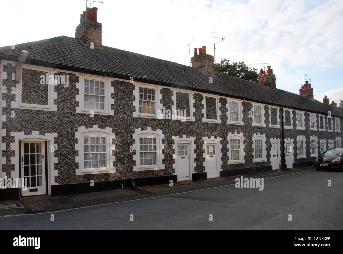 Fila di case terrazzate con pareti di pietra focaia nella città mercato di Holt, Norfolk, Inghilterra con alcune finestre superiori bloccate in, 2013 Foto Stock