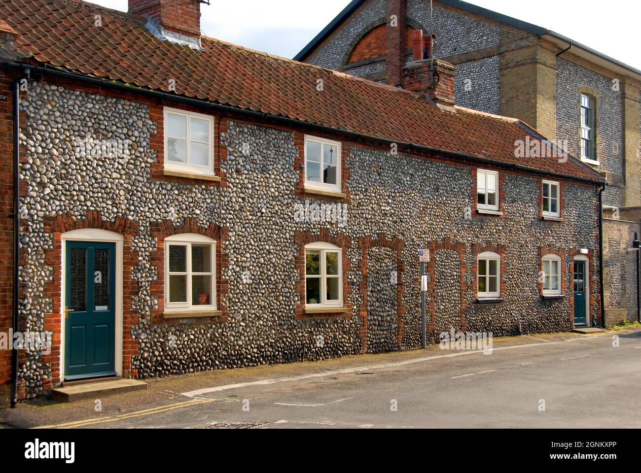 Due case con pareti di pietra focaia nella città mercato di Holt, Norfolk, Inghilterra, fatto da quattro cottage con due porte d'ingresso centrale bloccato, 2013 Foto Stock