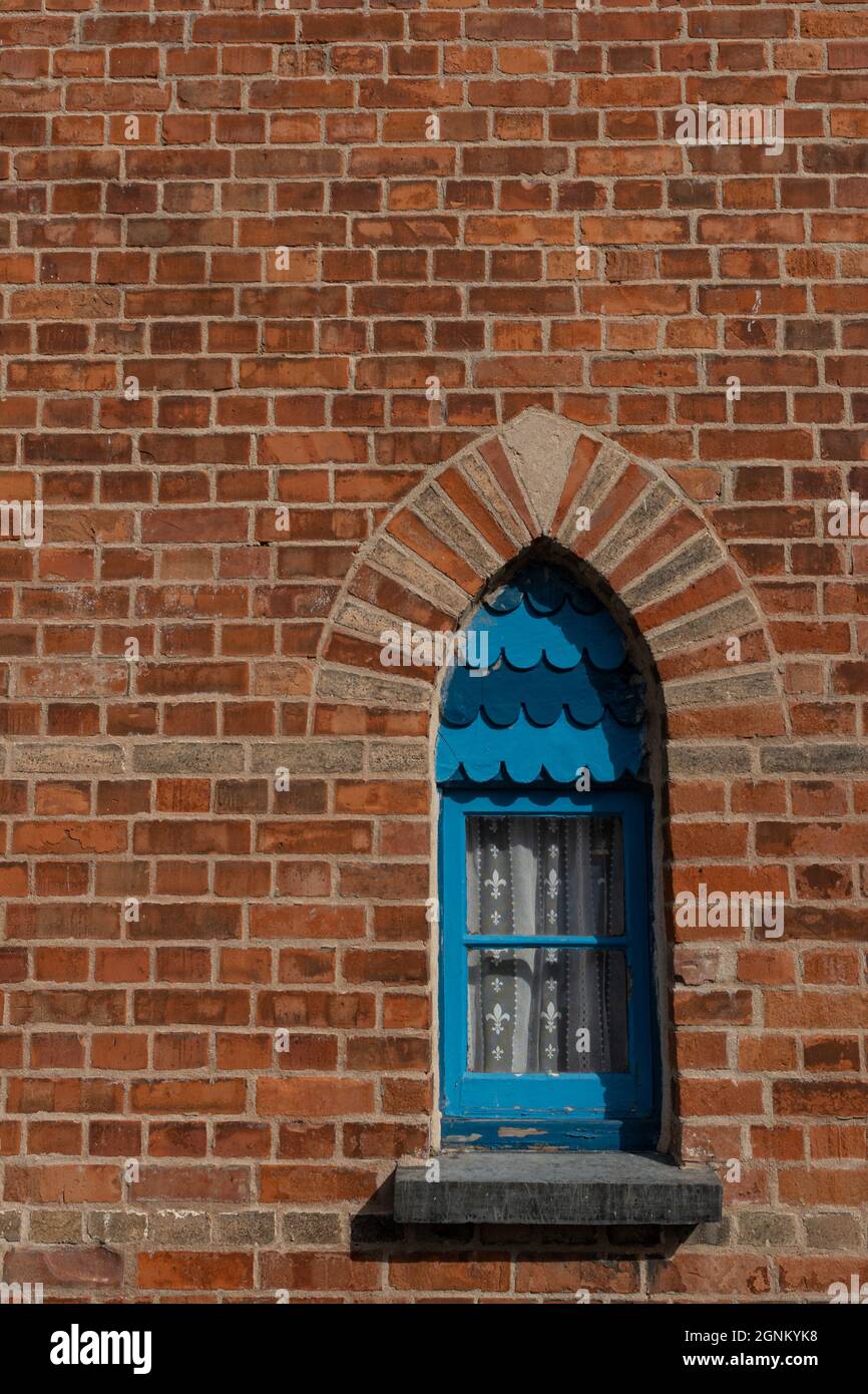 Porta ad arco blu con muratura in pietra decorativa in tradizionale mattone rosso Foto Stock