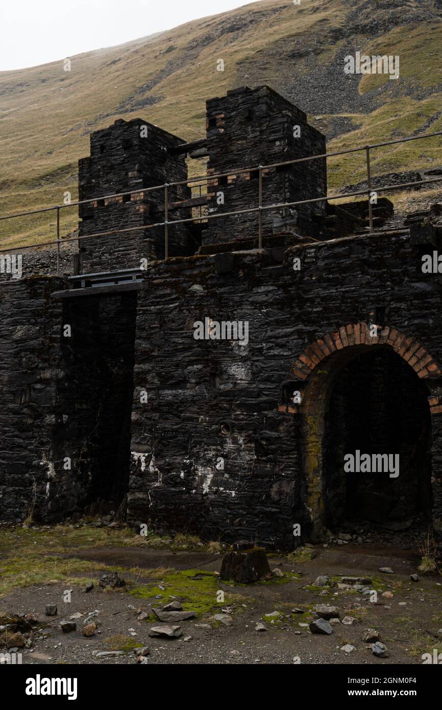 Edifici abbandonati in cava di ardesia con arco di mattoni nelle montagne gallesi Foto Stock
