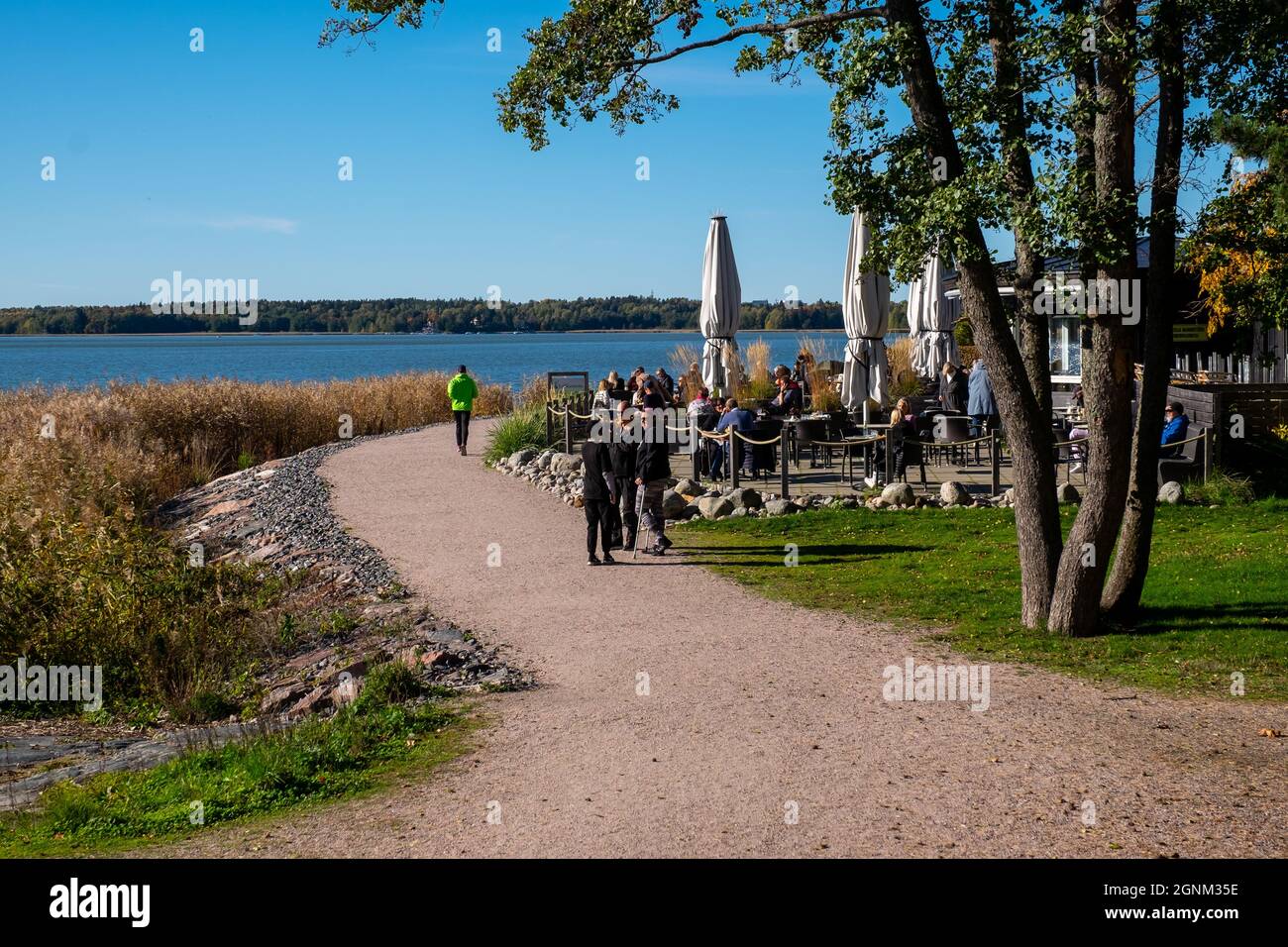 Helsinki / Finlandia - 26 SETTEMBRE 2021: La gente gode di una giornata autunnale soleggiato sul viale della spiaggia. Foto Stock