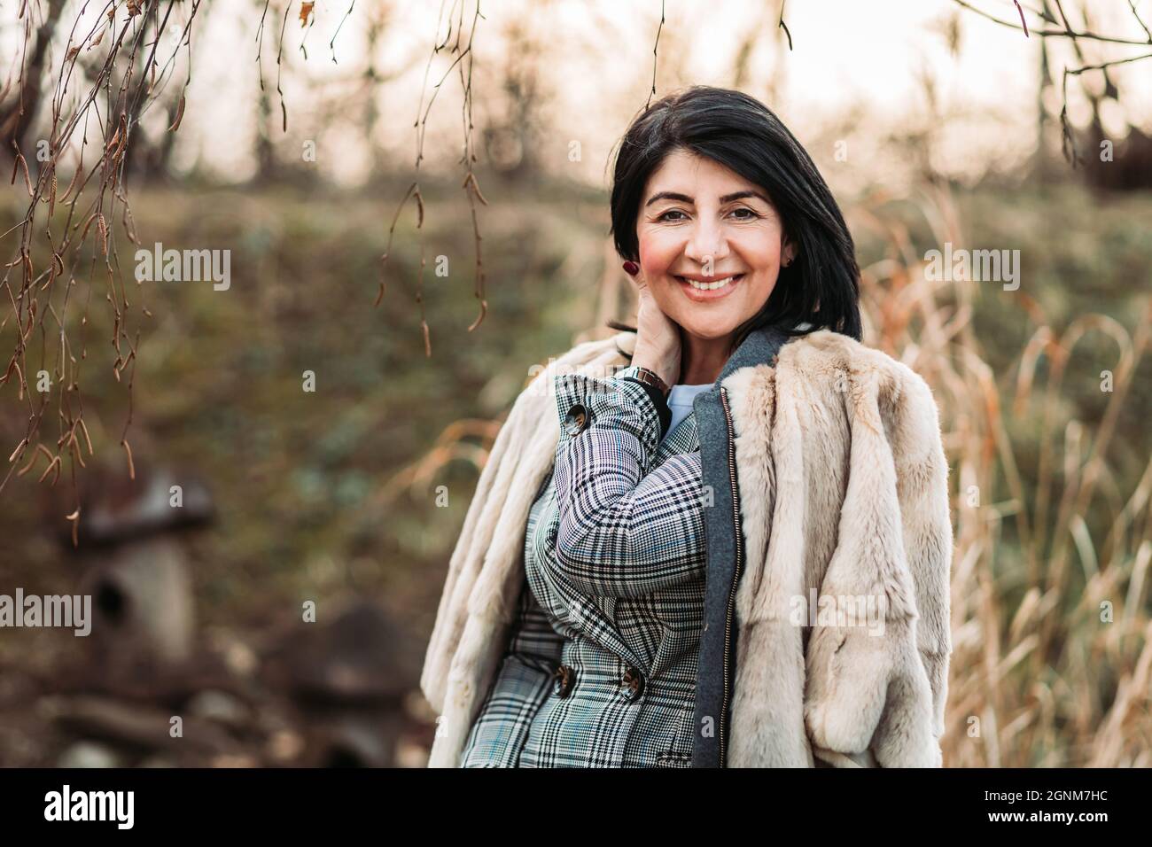 Donna moderna di mezza età in pelliccia di cappotto, sorridente Foto Stock