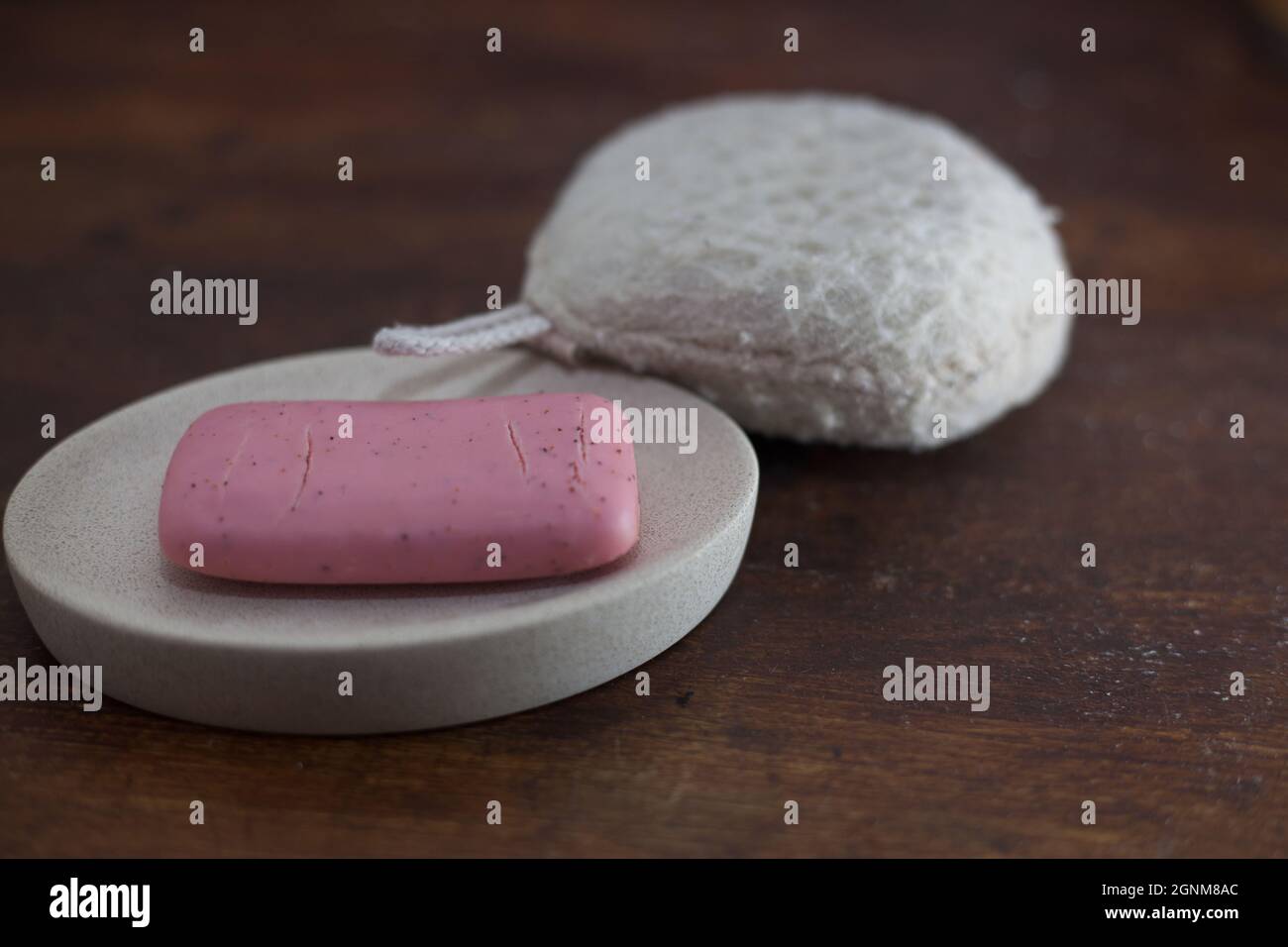 foto primo piano di una saponetta rosa e una spugna da bagno Foto Stock