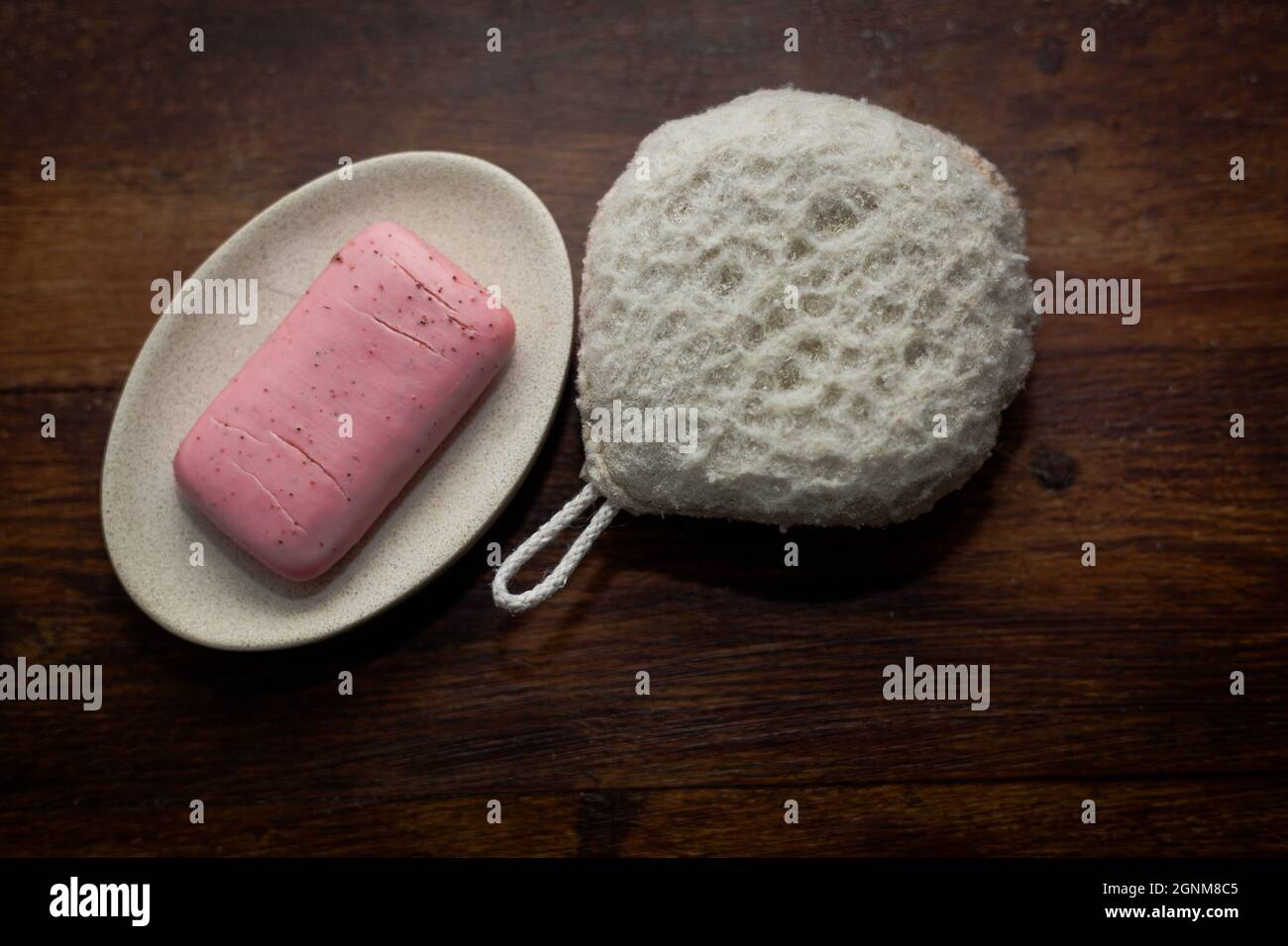 foto primo piano di una saponetta rosa e una spugna da bagno Foto Stock