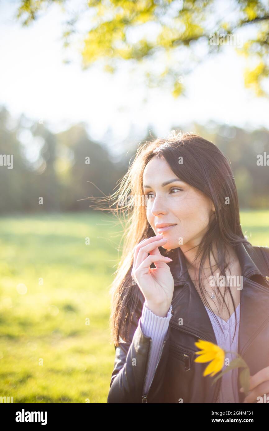 bruna ragazza nel parco in una giornata d'autunno soleggiato Foto Stock