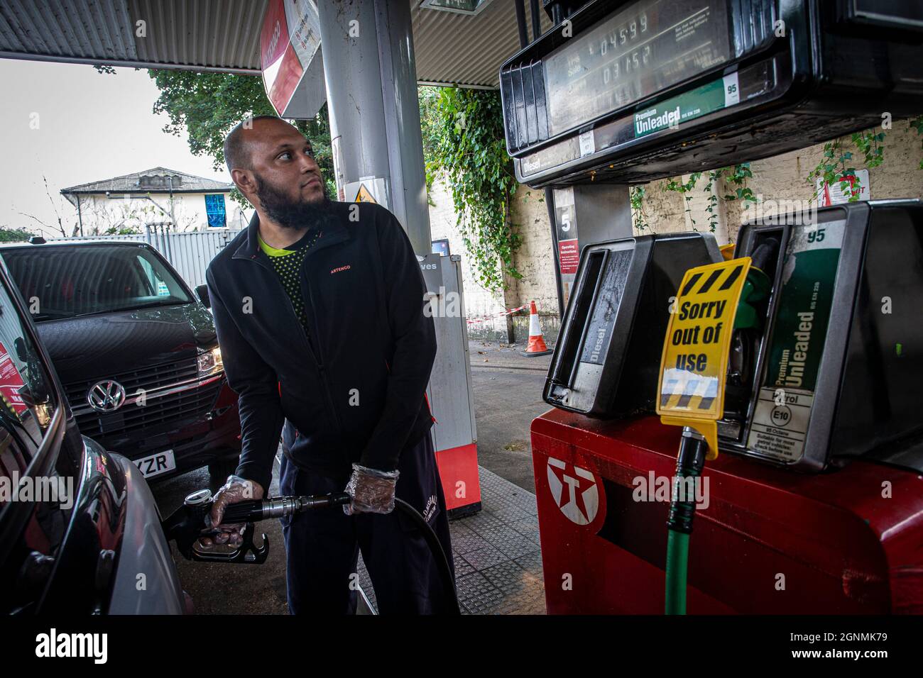Il motociclista è il serbatoio di riempimento accanto al cartello di fuori uso sulle pompe di benzina senza carburante presso la stazione di benzina a Londra, Regno Unito Foto Stock