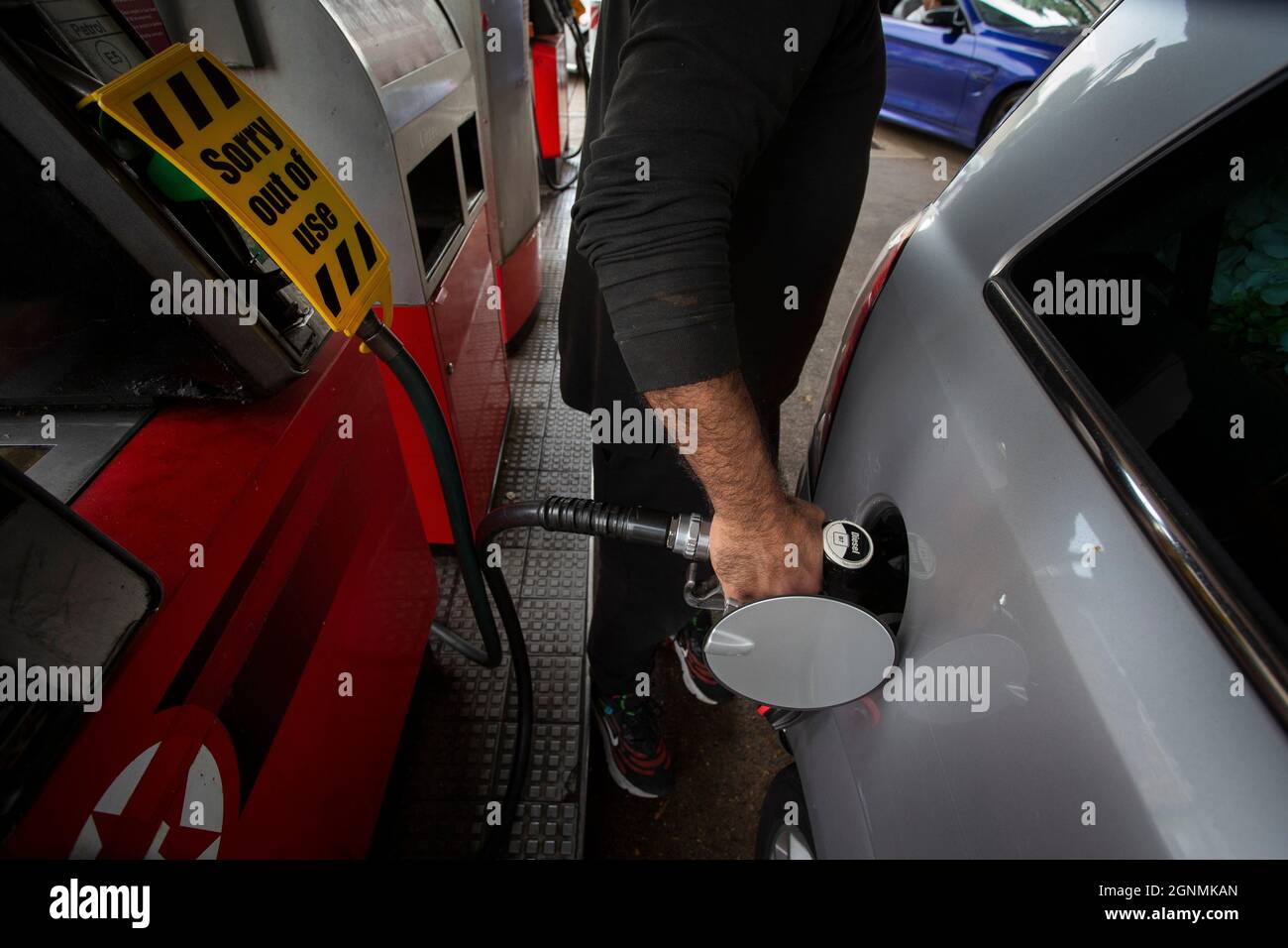 Il motociclista è il serbatoio di riempimento accanto al cartello di fuori uso sulle pompe di benzina senza carburante presso la stazione di benzina a Londra, Regno Unito Foto Stock