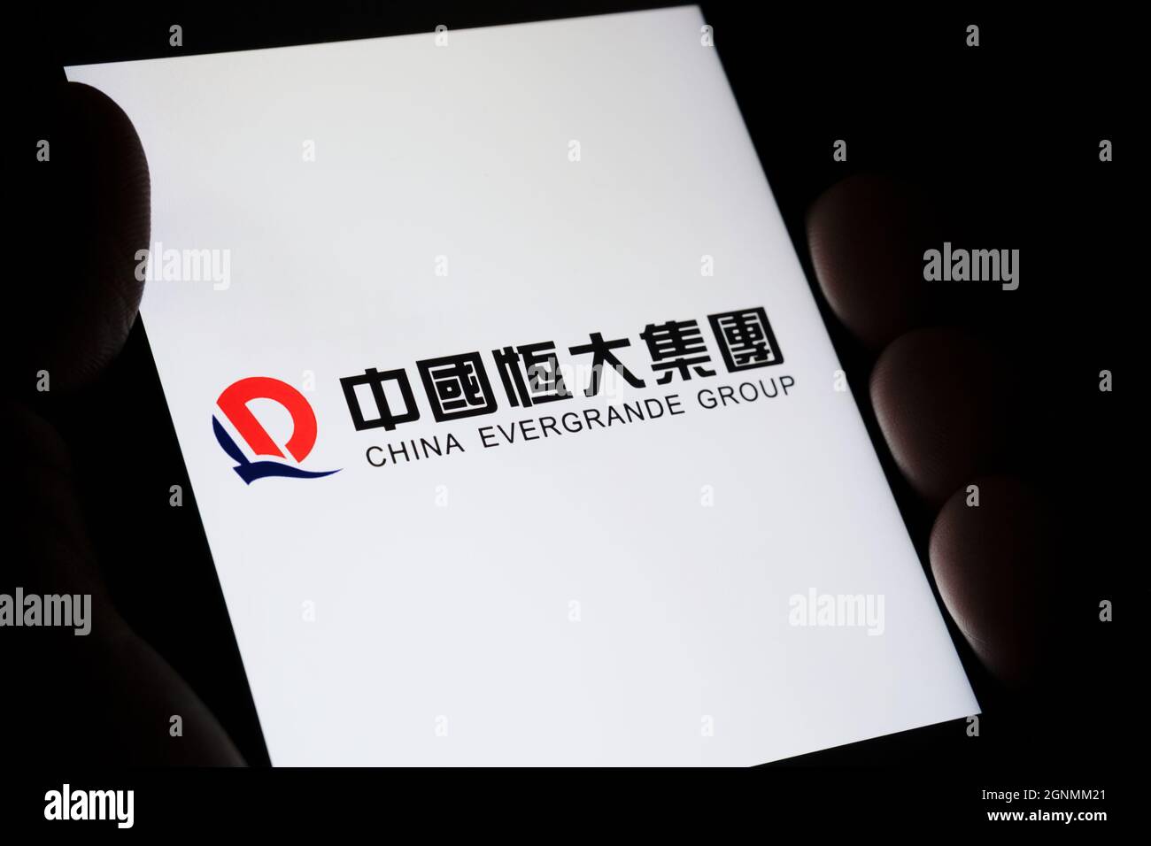 CINA EVERGRANDE GRUPPO logo con il suo nome in cinese visto su smartphone tenere in mano in una stanza buia. Concetto. Messa a fuoco selettiva. Stafford, Regno Unito Foto Stock