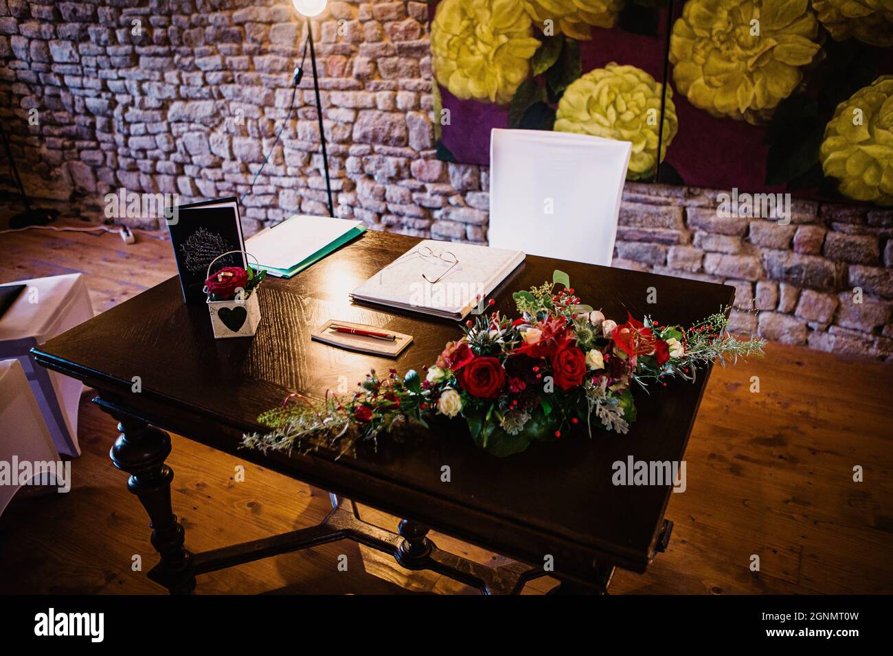 Un tavolo in un luogo organizzato per un'intima cerimonia di nozze civile con un background stonewall Foto Stock