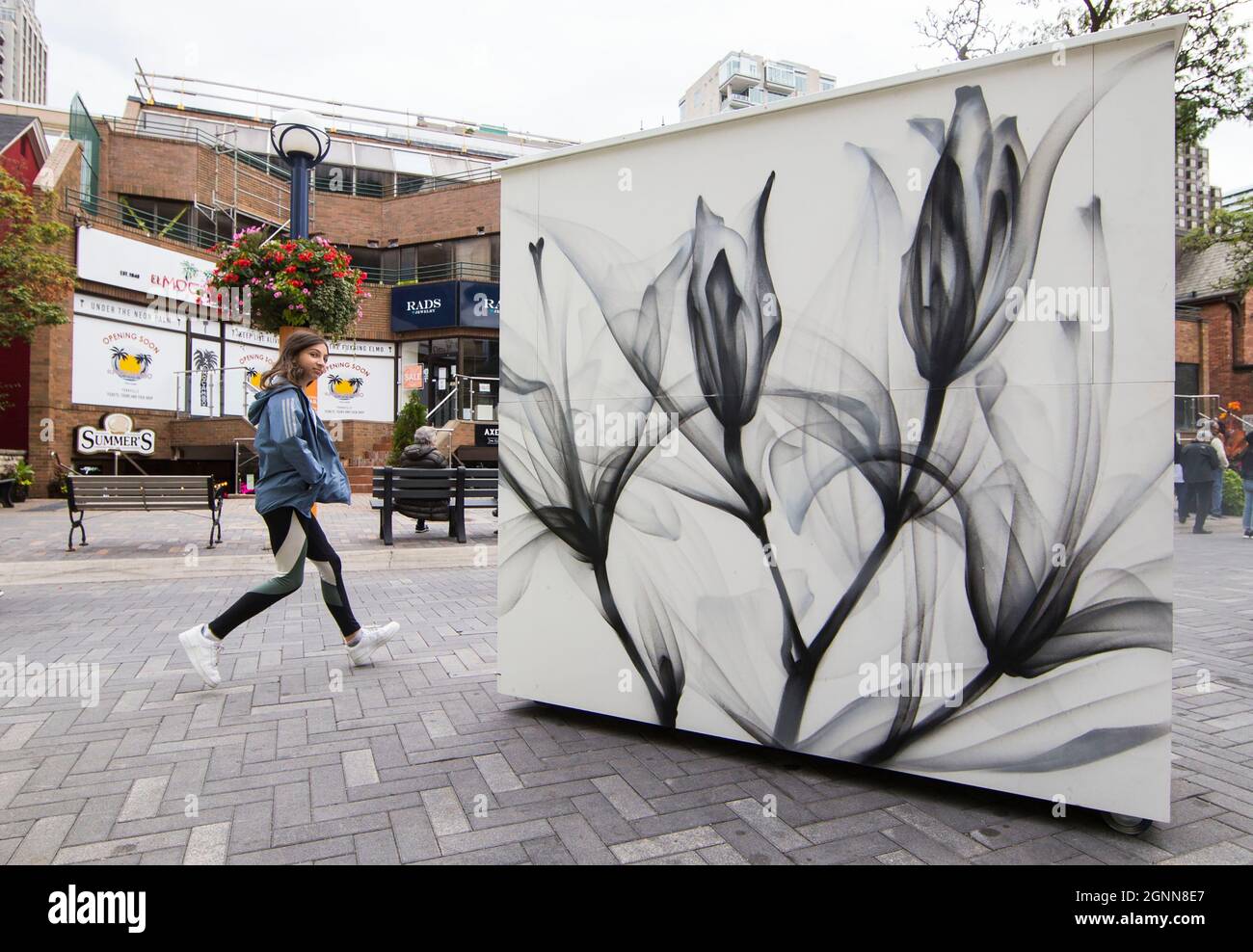 Toronto, Canada. 26 settembre 2021. Una ragazza cammina davanti a un murale durante il festival d'arte dei murales di Yorkville 2021 a Toronto, Canada, il 26 settembre 2021. Credit: Zou Zheng/Xinhua/Alamy Live News Foto Stock