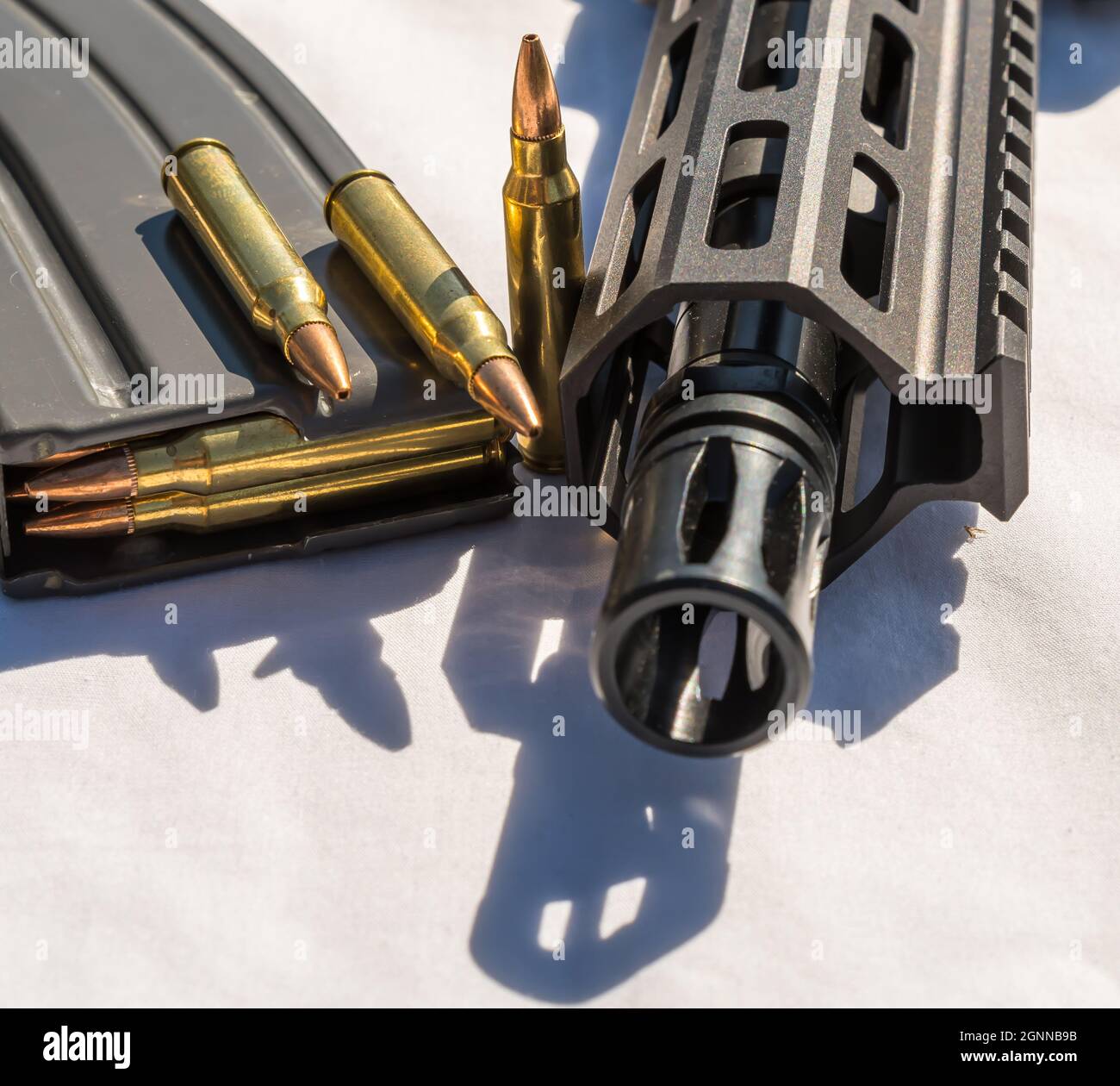 Una rivista di fucili carica di munizioni di calibro 223 con tre proiettili in più accanto a un fucile AR15 corto a barcelli Foto Stock