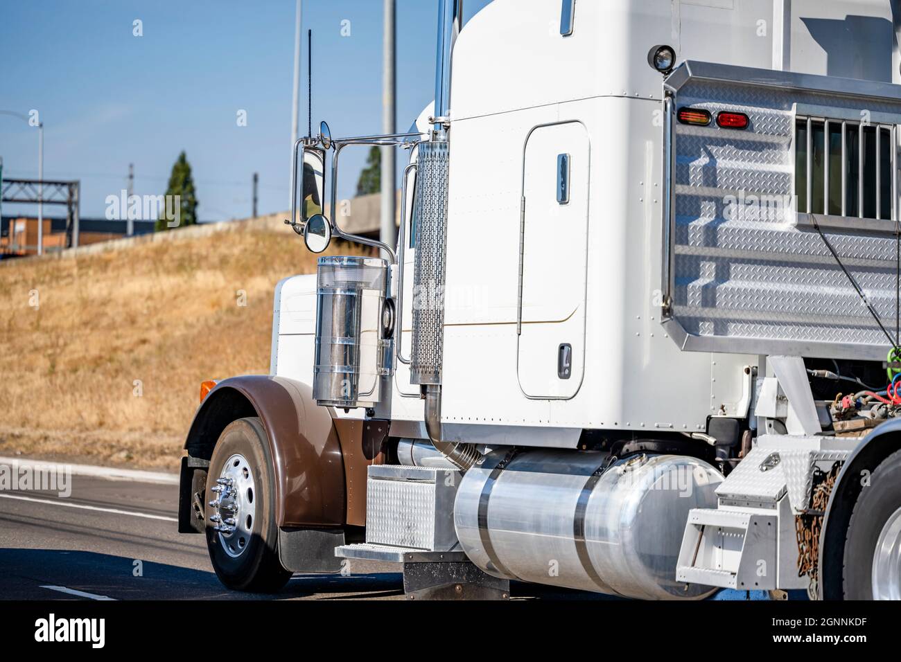 Potente trattore semi-camion classico bianco e marrone con grande carro di perforazione, con posto di guida per camion e parete di protezione sulla parete posteriore della cabina e molto chr Foto Stock