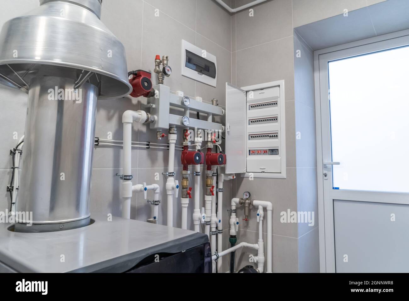 Distributore automatico di riscaldamento centralizzato in locale caldaia. Foto Stock