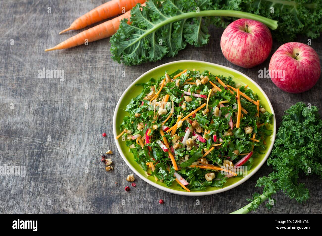 Insalata sana di cavolo con carote, mela e noce su sfondo di legno. Delizioso cibo fatto in casa Foto Stock