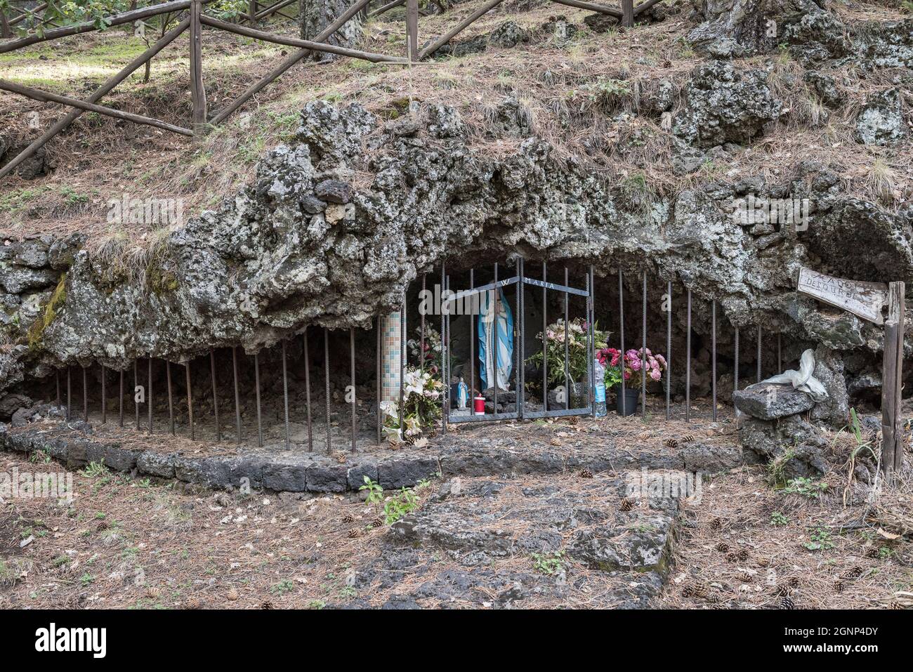 Un santuario a bordo strada della Madonna di Lourdes, costruito in una piccola grotta di lava sulle pendici dell'Etna, Sicilia, Italia Foto Stock