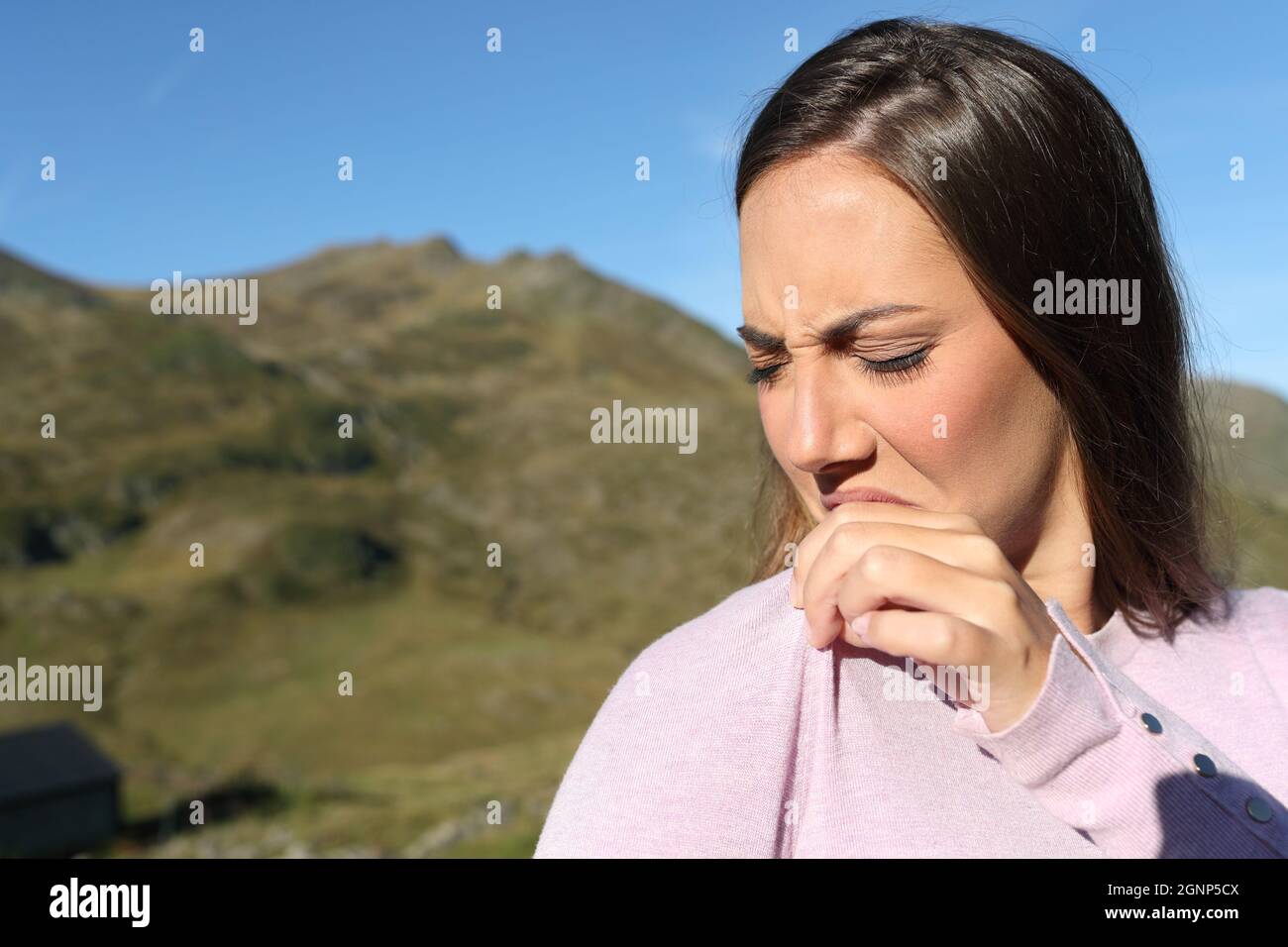 Donna disgustata che puzzava abiti stinky in montagna Foto Stock