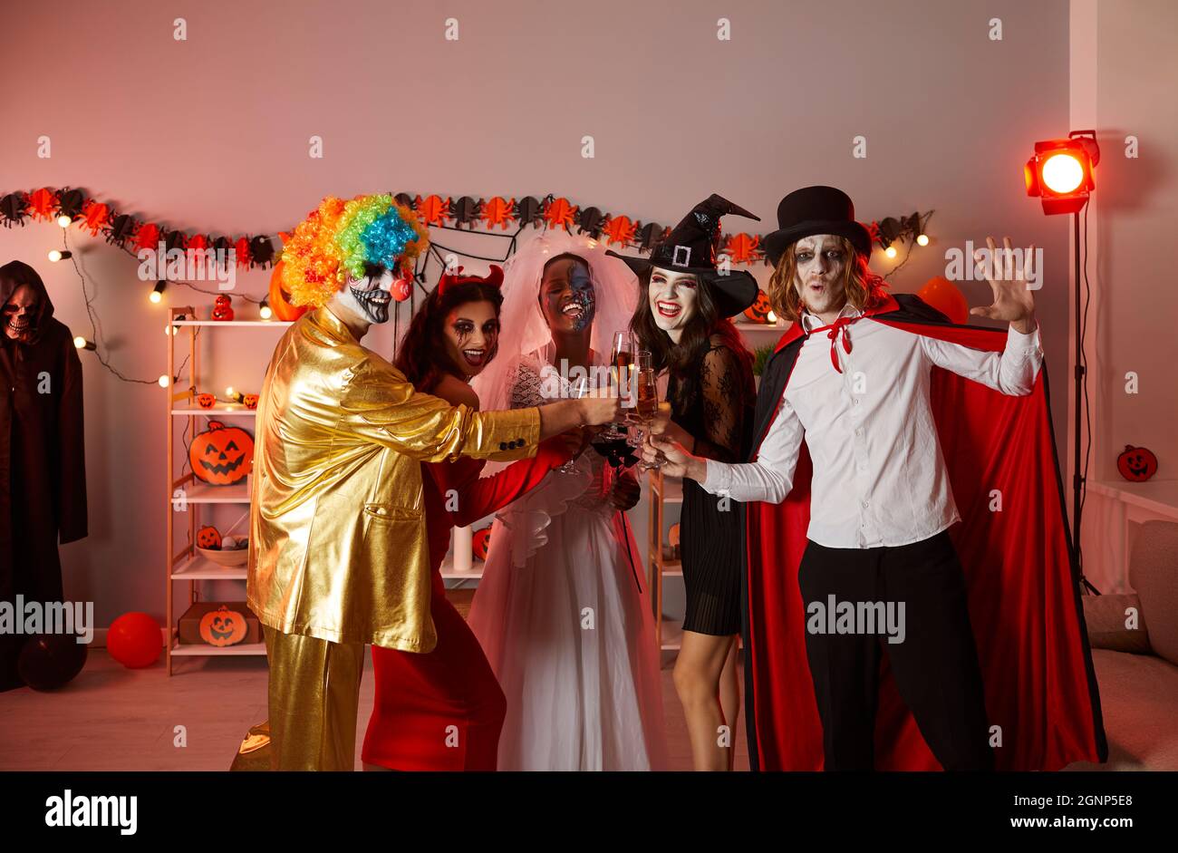 Gruppo di giovani felici che bevono e si divertono in una festa di Halloween a casa Foto Stock