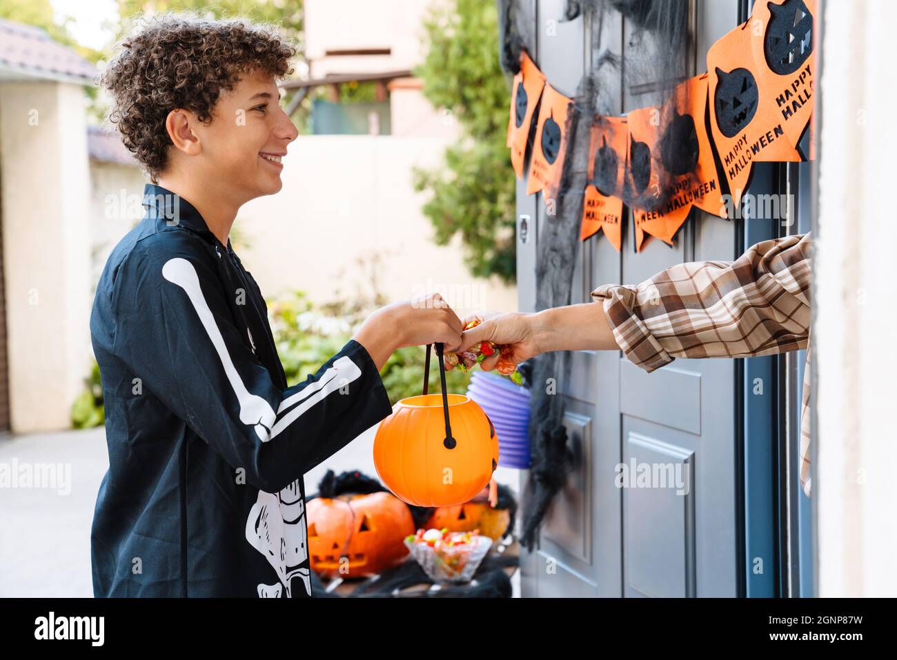 Ragazzo bianco vestito come trick-or-treating scheletro durante Halloween all'aperto Foto Stock
