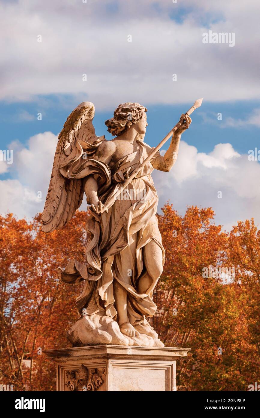 Autunno a Roma. Bella statua d'angelo con la Santa Lance di Longino in cima al Ponte Sant'Angelo, eretta nel XVII secolo, con foglie atumne Foto Stock