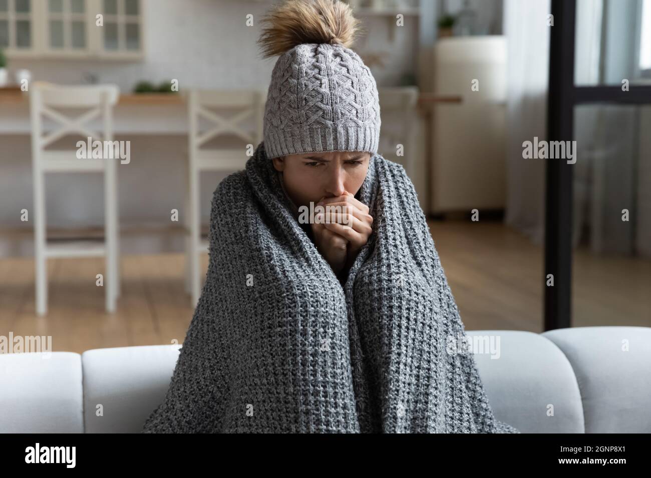 Donna malata si sente fredda in casa senza riscaldamento Foto Stock