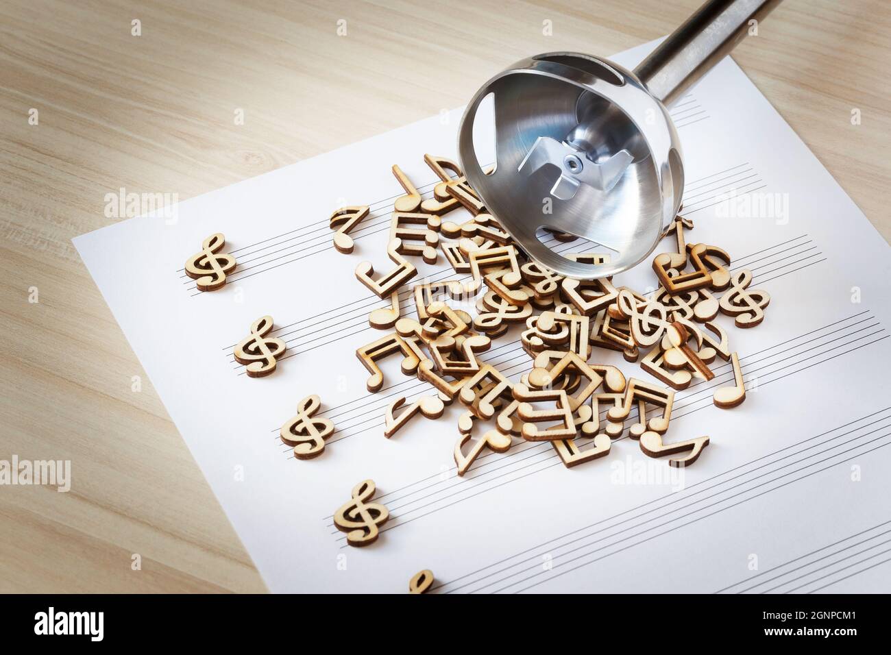 Un mazzo di note musicali in legno su un foglio di musica con una testa mixer per la miscelazione. Concetto di creazione musicale Foto Stock