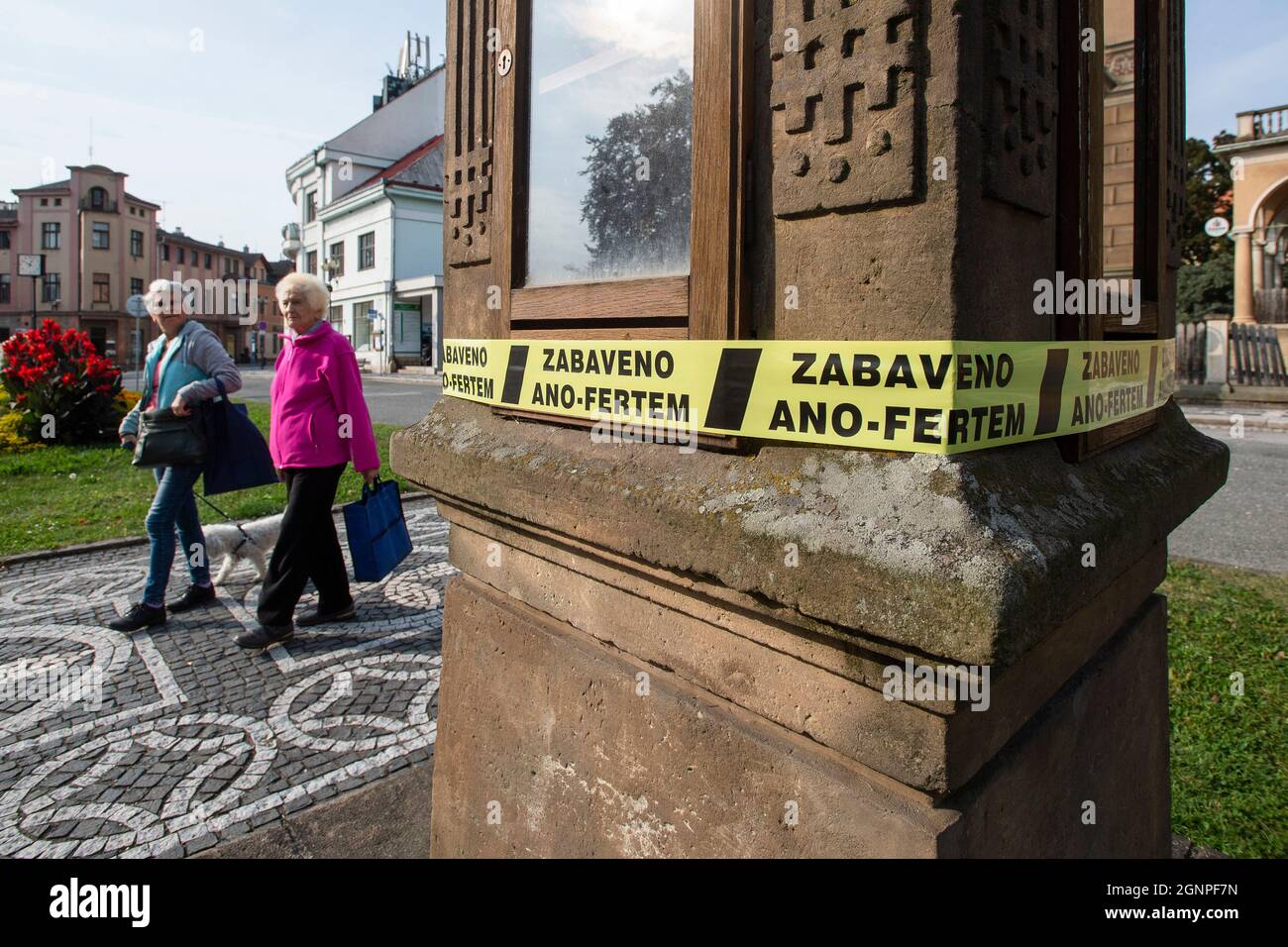 Il gruppo Million Moments for Democracy ha messo i nastri di sequestro leggendo 'Seized by ANO-FERT' in circa 30 città ceche questa mattina, lunedì 27 settembre 2021, per sensibilizzare la preoccupazione di Agrofert relativa a PM Andrej Babis (ANO) che cresce sempre più in profondità nel paese. L'avvenimento ha lo scopo di mettere in guardia contro possibili scenari che potrebbero verificarsi se il governo che emerge dalle elezioni generali dell'ottobre 8-9 è formato da ANO di Babis. All'inizio di questa mattina, i volontari si sono avvolti intorno a strutture pubbliche selezionate, come fermate di autobus, statue e fontane, con i nastri di sequestro giallo della proprietà. Foto Stock