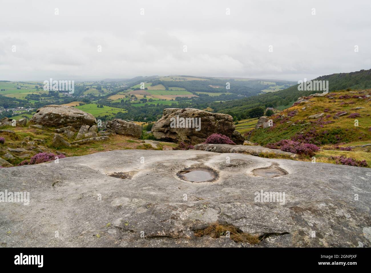 Dalle alture di Baslow Edge le nuvole grigie e la nebbia si aggirano sulla campagna del Derbyshire. Foto Stock