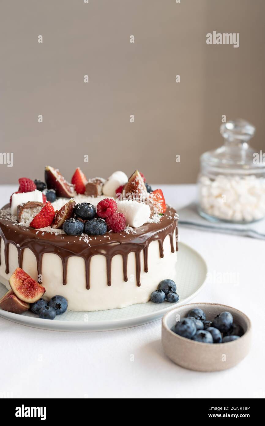 torta di compleanno con diversi frutti di bosco, marshmallows e gocce di cioccolato Foto Stock