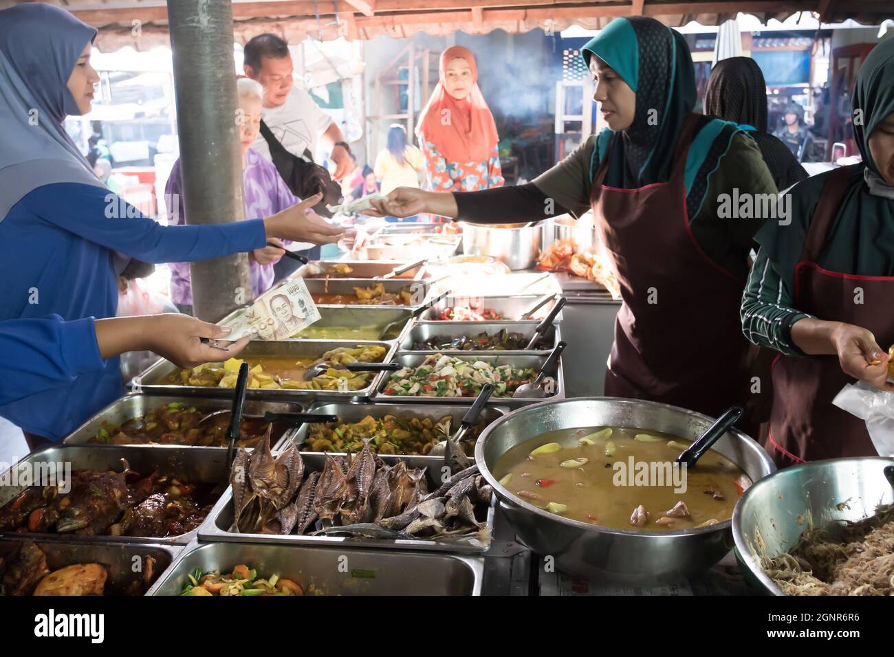 Narathiwat, Thailandia - 13 LUGLIO 2019: Vendita locale di cibo tailandese-malese in un mercato umido. Attenzione alle banconote. Narathiwat. Foto Stock