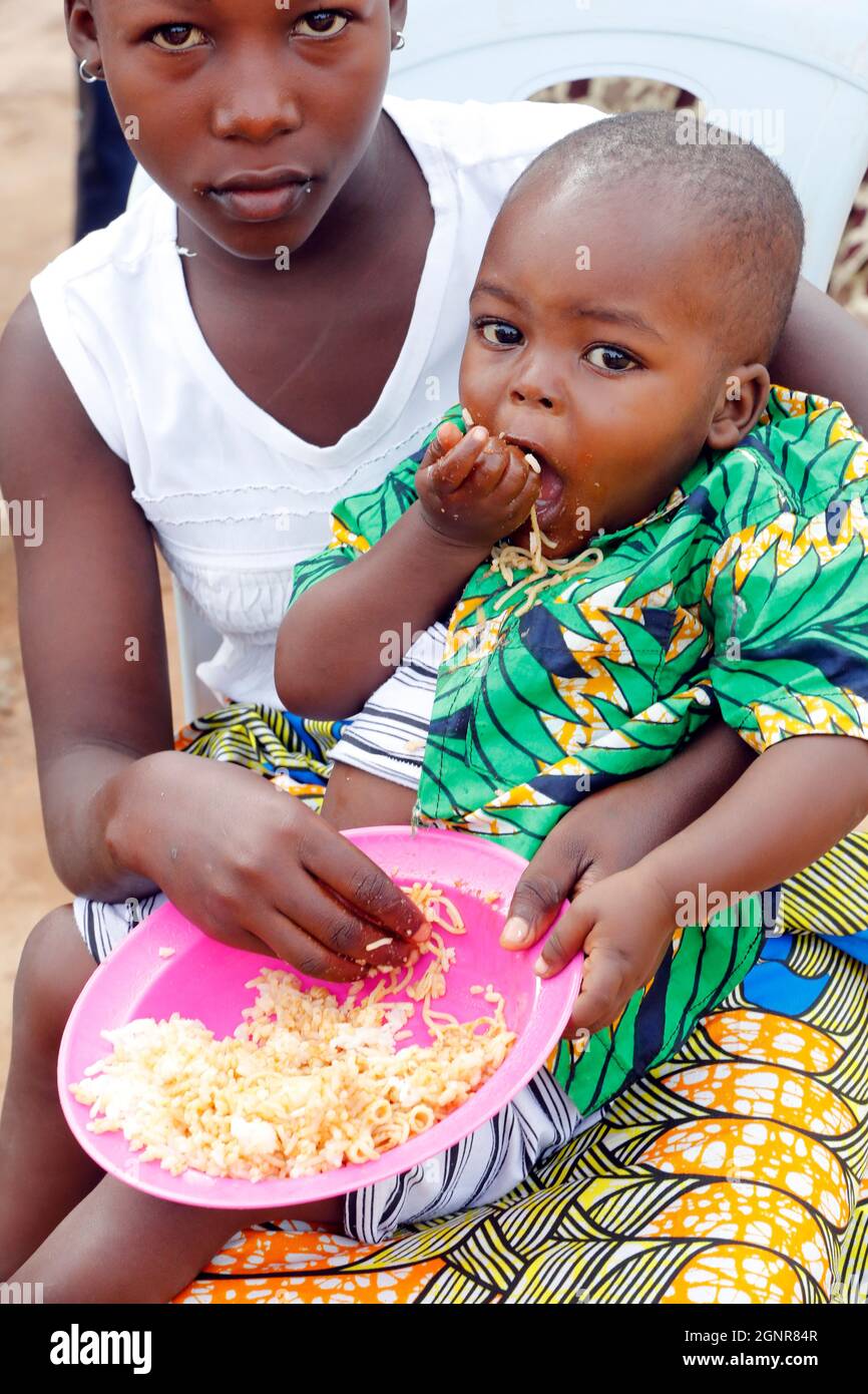 I bambini mangiano riso e spaghetti a pranzo. Benin. Foto Stock
