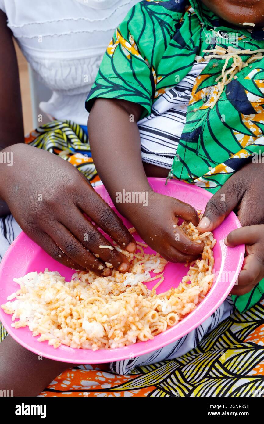 I bambini mangiano riso e spaghetti a pranzo. Benin. Foto Stock