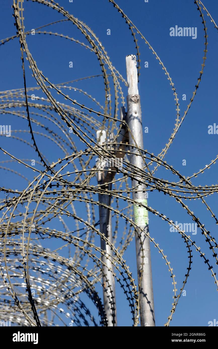 Recinzione filo spinato contro cielo blu. Criminalità e punizione concetto foto. Ginevra. Svizzera. Foto Stock