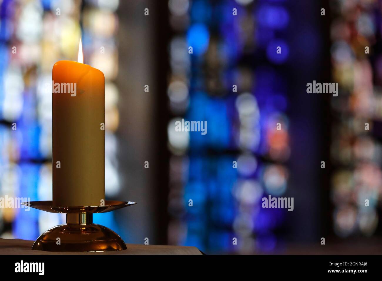 Notre Dame de Plaimpalais chiesa. Luce di candela contro una vetrata in una chiesa durante una celebrazione religiosa. Francia. Foto Stock