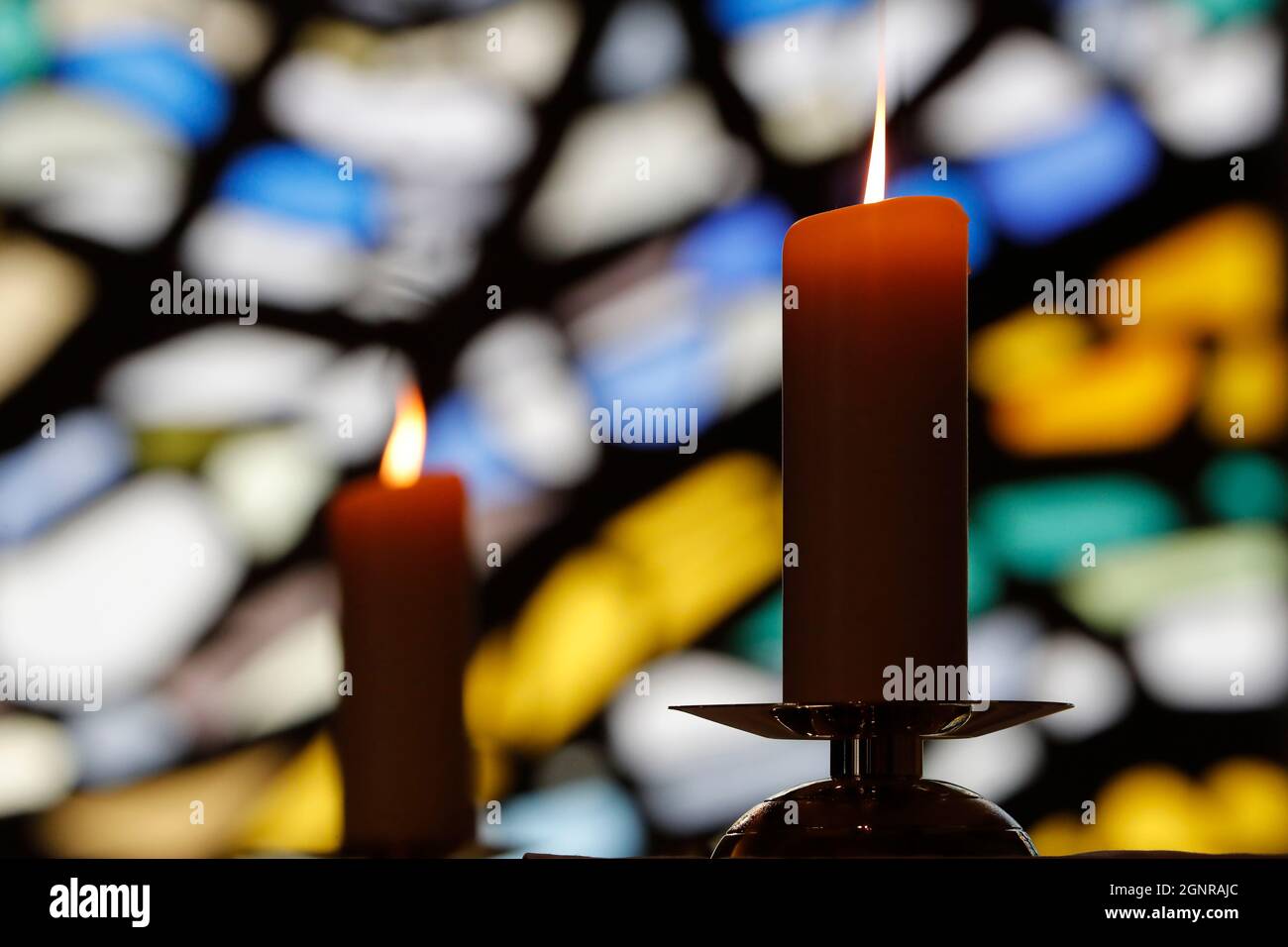 Notre Dame de Plaimpalais chiesa. Luce di candela contro una vetrata in una chiesa durante una celebrazione religiosa. Francia. Foto Stock