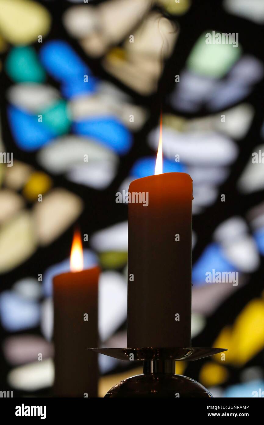 Notre Dame de Plaimpalais chiesa. Luce di candela contro una vetrata in una chiesa durante una celebrazione religiosa. Francia. Foto Stock