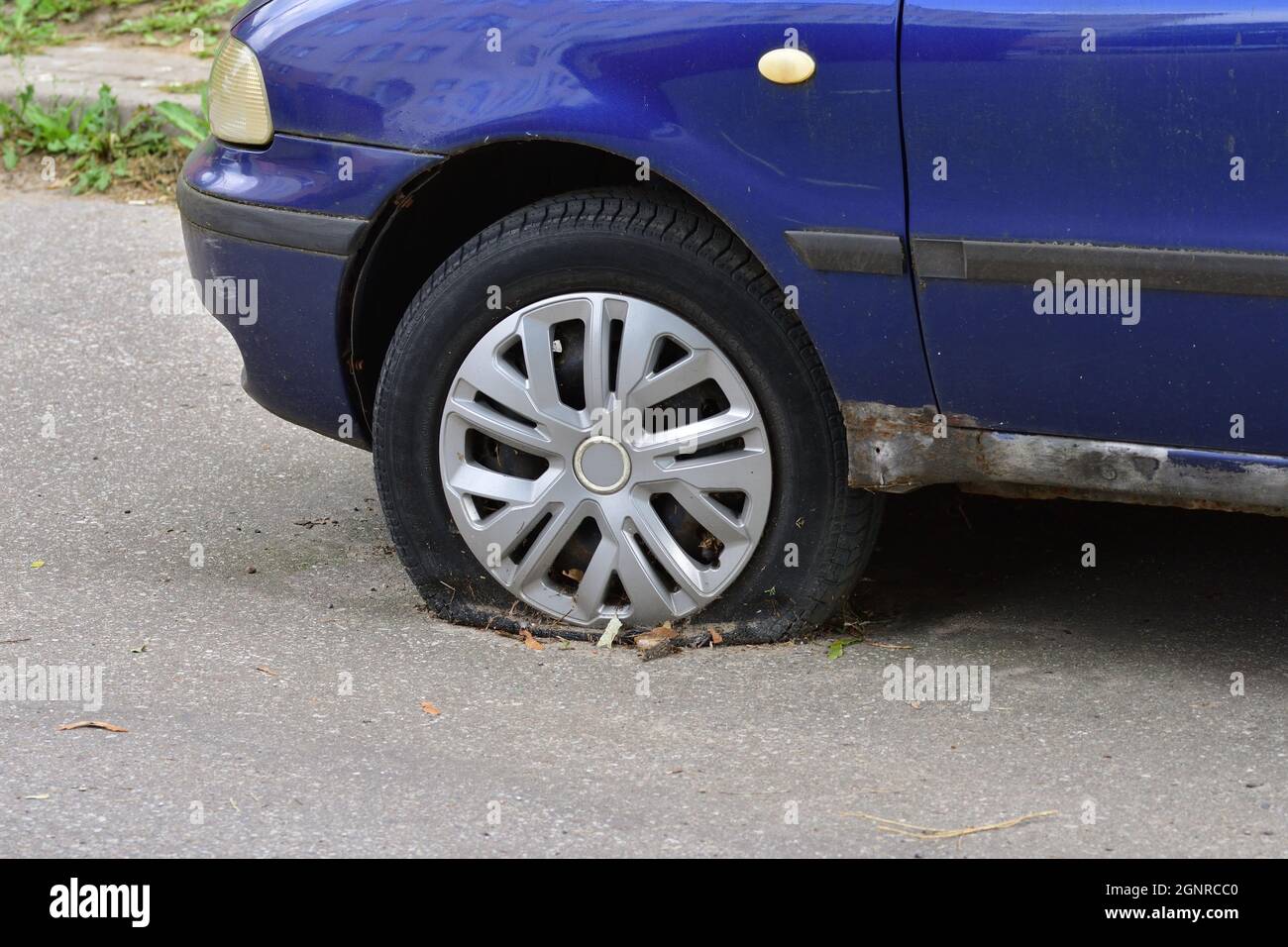 La vettura danneggiata è in piedi su pneumatici sgonfi nel parcheggio. Rottami. Foto Stock