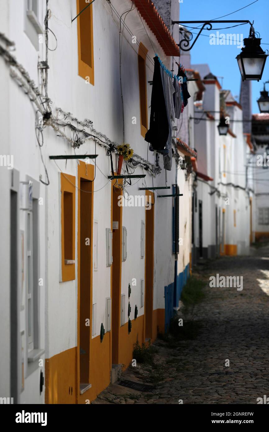 Strada di pietra da tipiche case bianche e gialle. Evora. Portogallo. Foto Stock