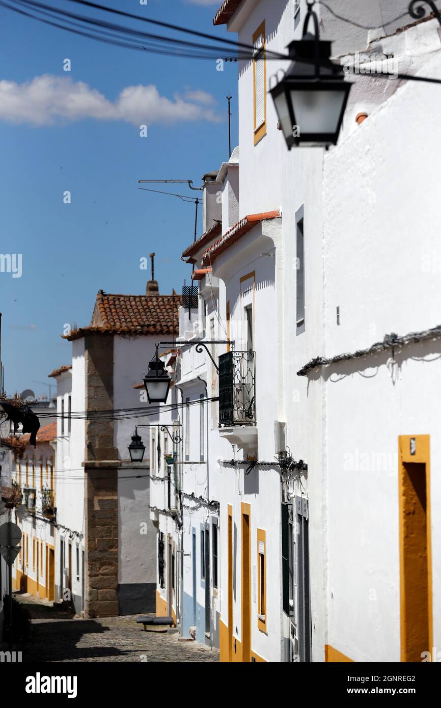 Strada di pietra da tipiche case bianche e gialle. Evora. Portogallo. Foto Stock