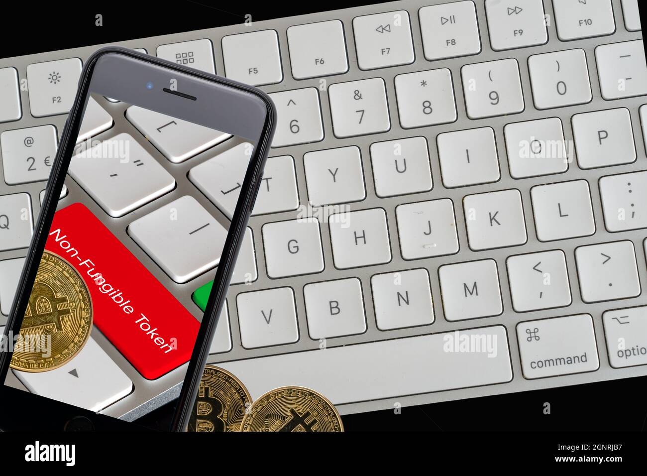 Cardiff Glamorgan Galles UK Settembre 25 2021 concetto di token non fungibile con tastiera per computer, telefono cellulare e valuta criptata bitcoin Foto Stock
