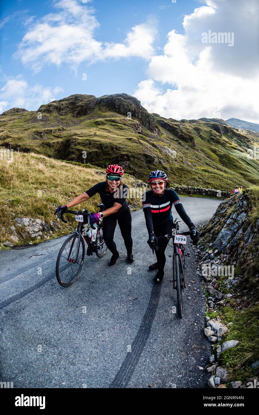 Due ciclisti femminili nel Fred Whitton Challenge, Hardknott Pass, Cumbria. Foto Stock