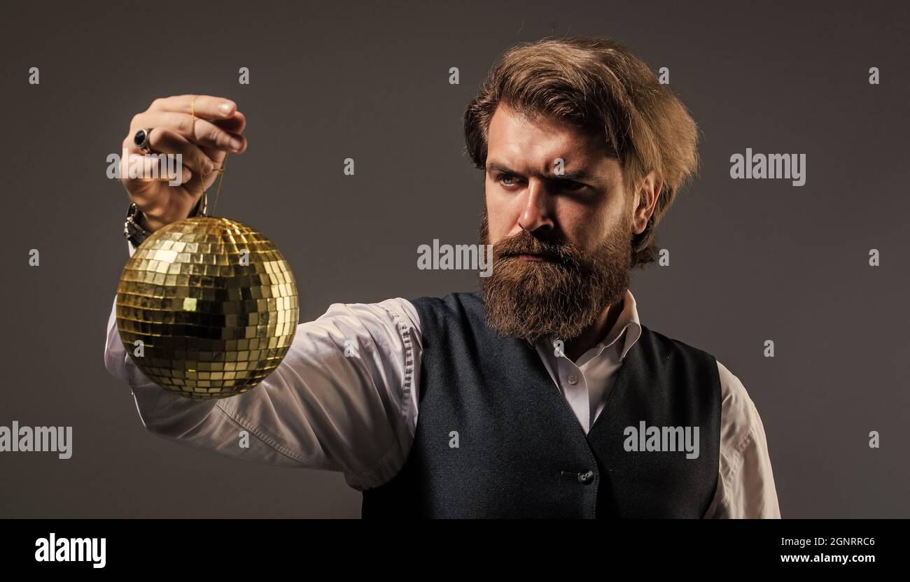 tempo per la festa. discoteca super cool. hipster brutale maturo. uomo con barba tenere specchio disco palla. concetto di festa aziendale. disco uomo in tuta Foto Stock