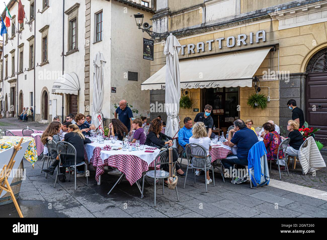 SUTRI ITALIA, REGNO UNITO. 27 Settembre 2021. La gente può cenare all'aperto in un ristorante di Sutri, Lazio, in una giornata calda e umida. Dal momento che il governo italiano ha iniziato a rilassare le regole di blocco più persone sono viste mangiare in ristoranti interni e all'aperto. I clienti che si siedono all'interno devono mostrare un Green Pass che certifica che il titolare è vaccinato doppio e senza covid. Credit: amer Ghazzal/Alamy Live News Foto Stock