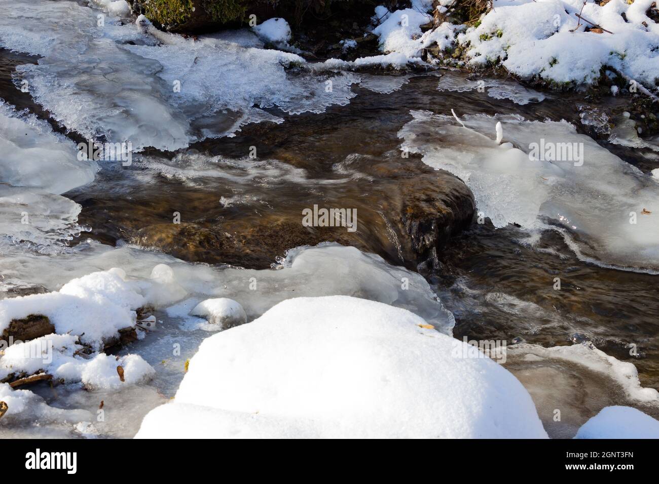 Acqua che scorre sotto ghiaccio fondente, concetto di riscaldamento globale Foto Stock