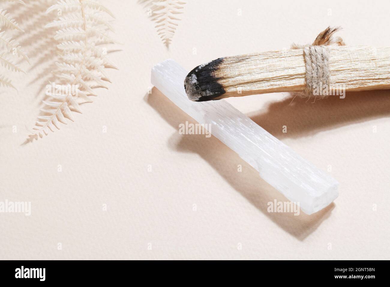 Bastone Palo Santo, selenite su sfondo beige, rock magico per rituale, stregoneria, pratica spirituale, meditazione. Concetto esoterico di equilibrio vitale Foto Stock