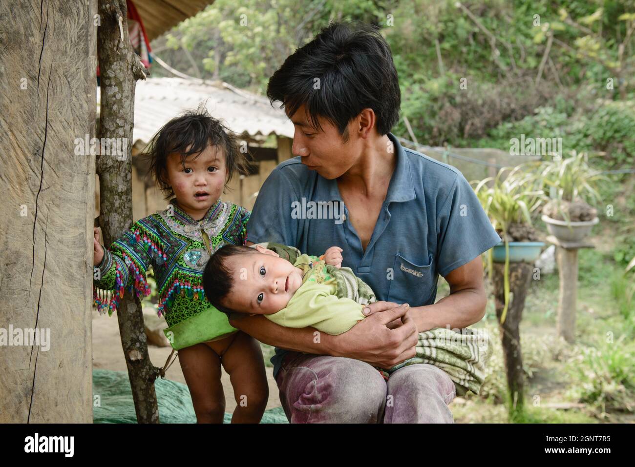 Sapa, Vietnam - 14 aprile 2016: Padre vietnamita con figli a casa mentre la moglie è al lavoro. Paternità in Asia, aree rurali povere. Foto Stock