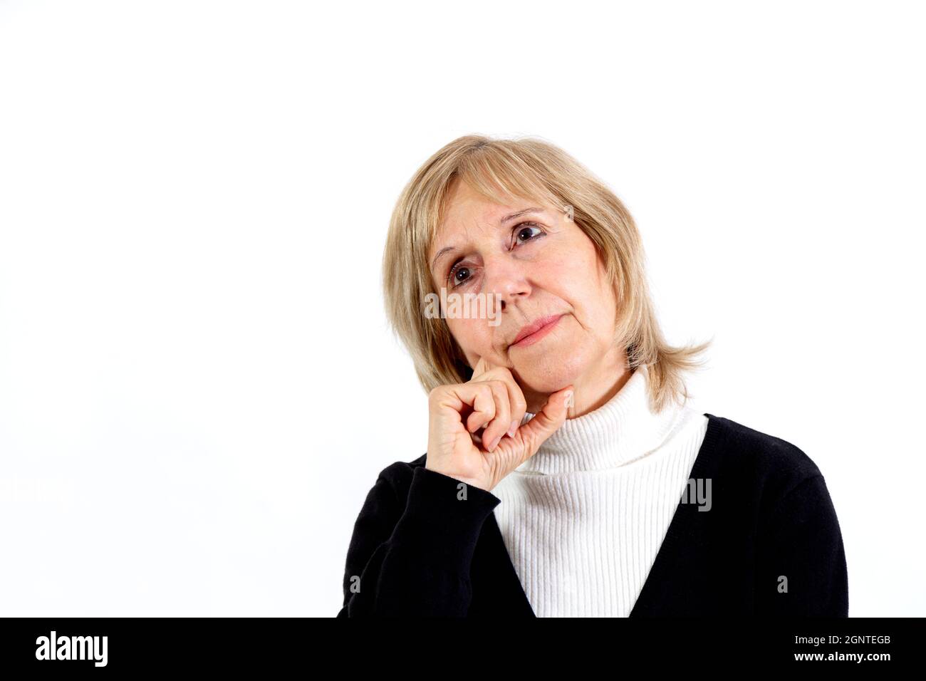 Donna anziana in posizione di pensiero con la mano sul viso. Sfondo bianco. Circa 65 anni donna. Foto Stock