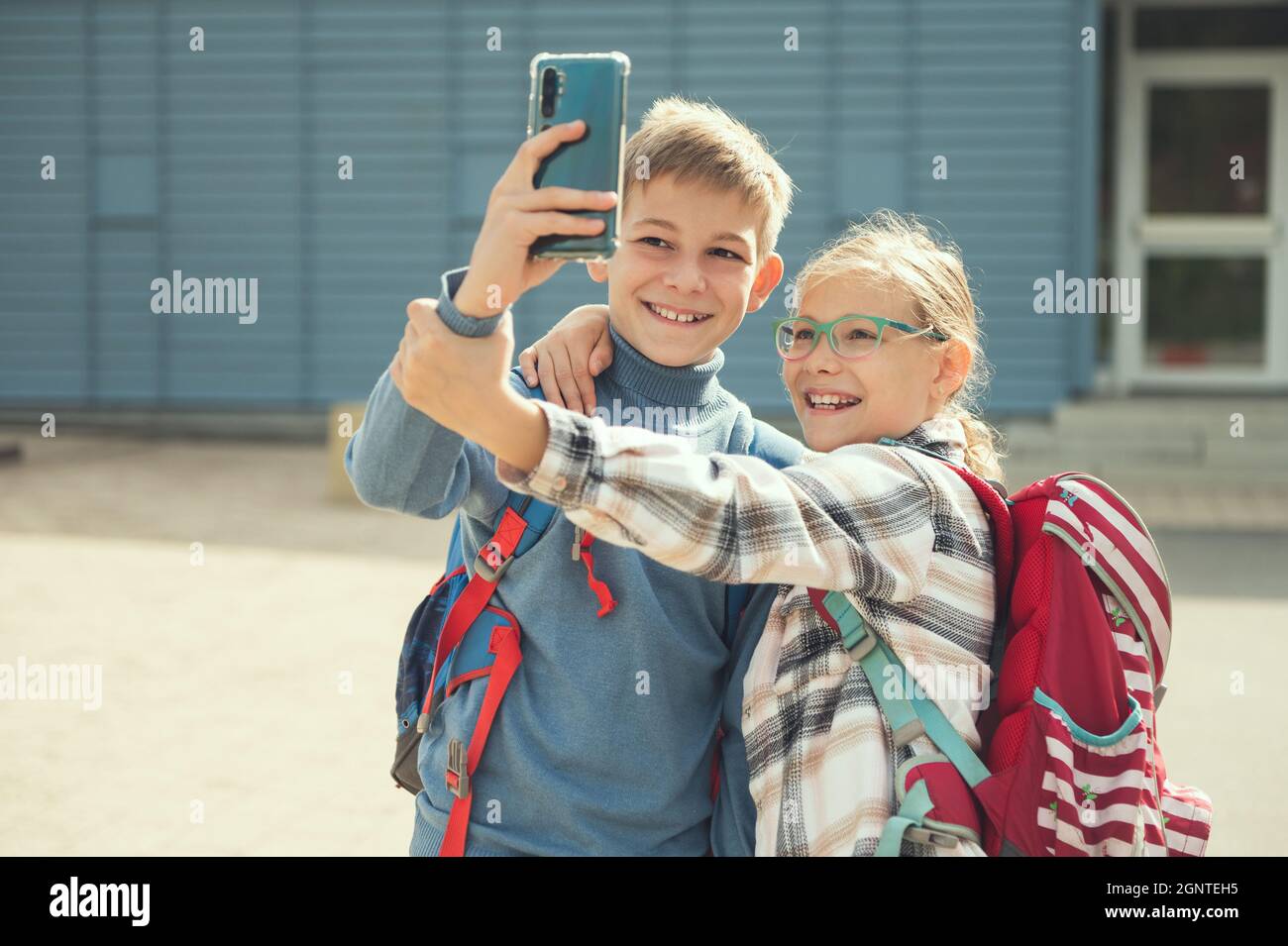 Ragazzi felici scuola bambini giocare e fare selfie con cellulare a scuola dopo le lezioni Foto Stock